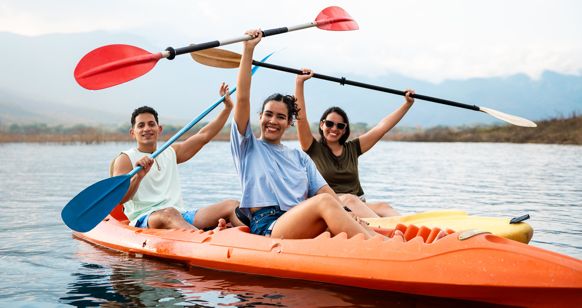 Three friends kayaking on a lake.