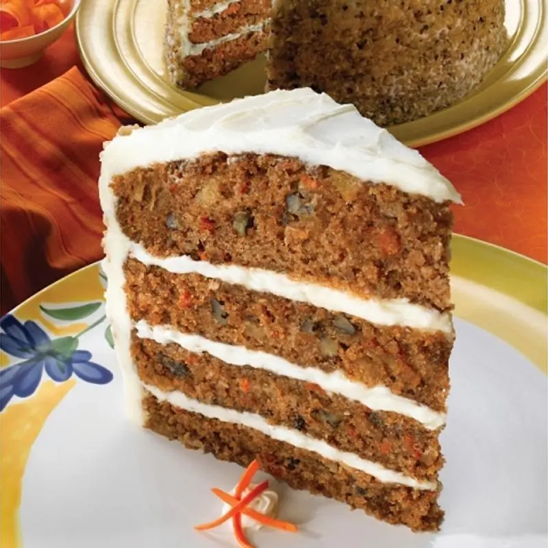 Slice of layered carrot cake with frosting