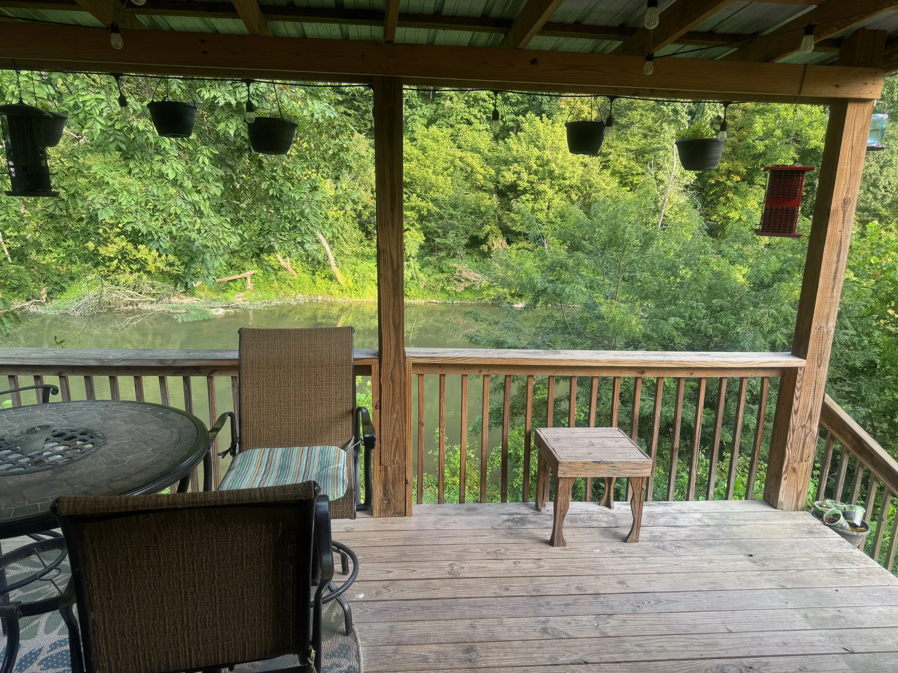 Covered wooden deck overlooking pond and trees
