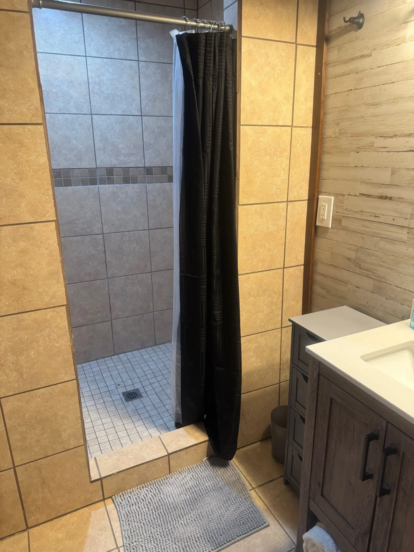 Tiled walk-in shower with black curtain