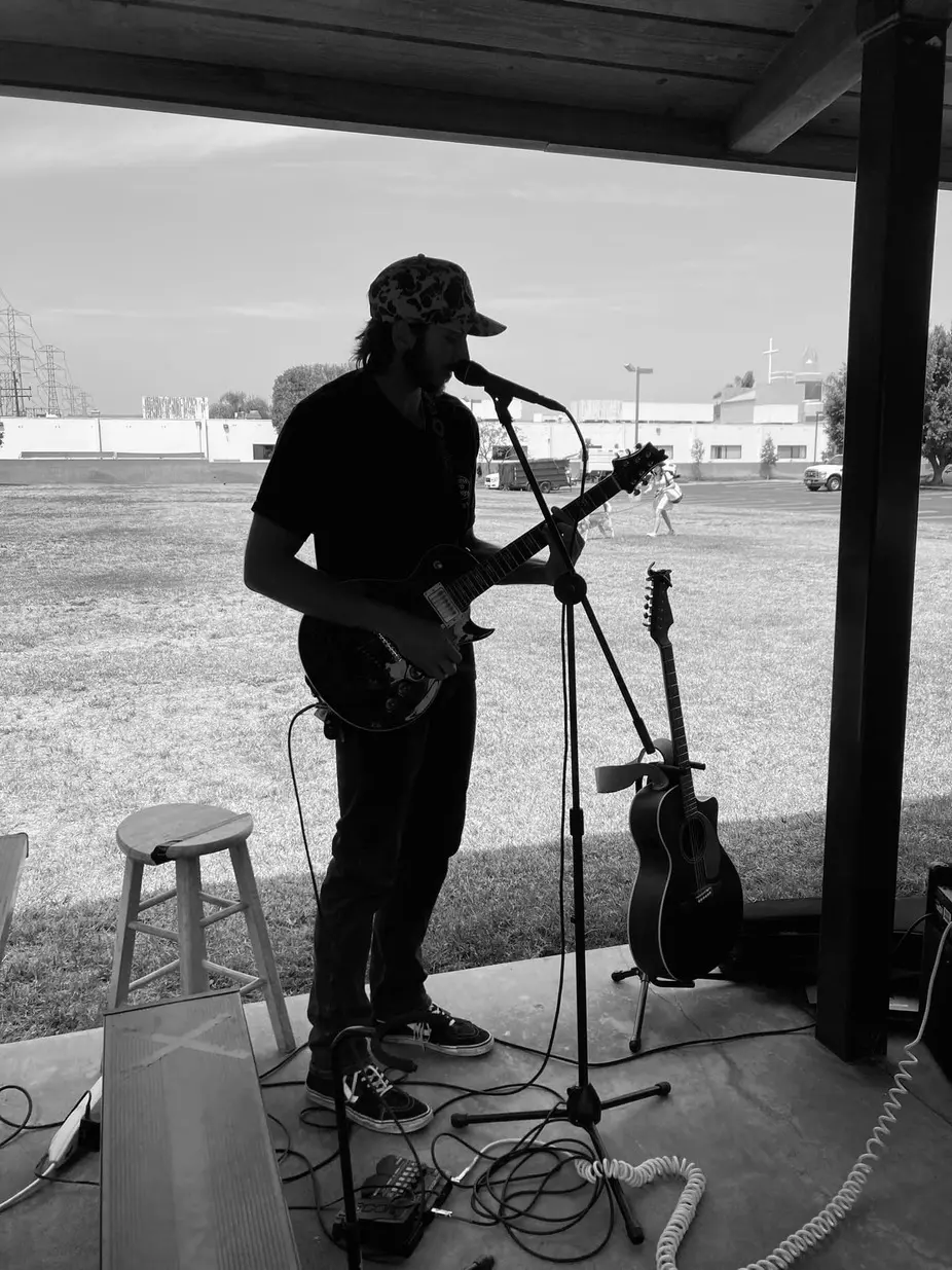 Silhouetted musician singing and playing electric guitar