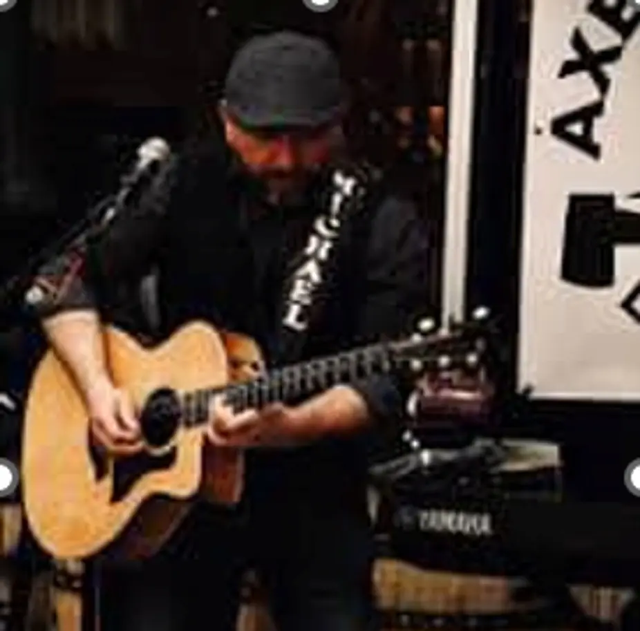 Musician playing acoustic guitar on stage