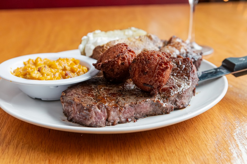 Steak with hush puppies, baked potato, corn